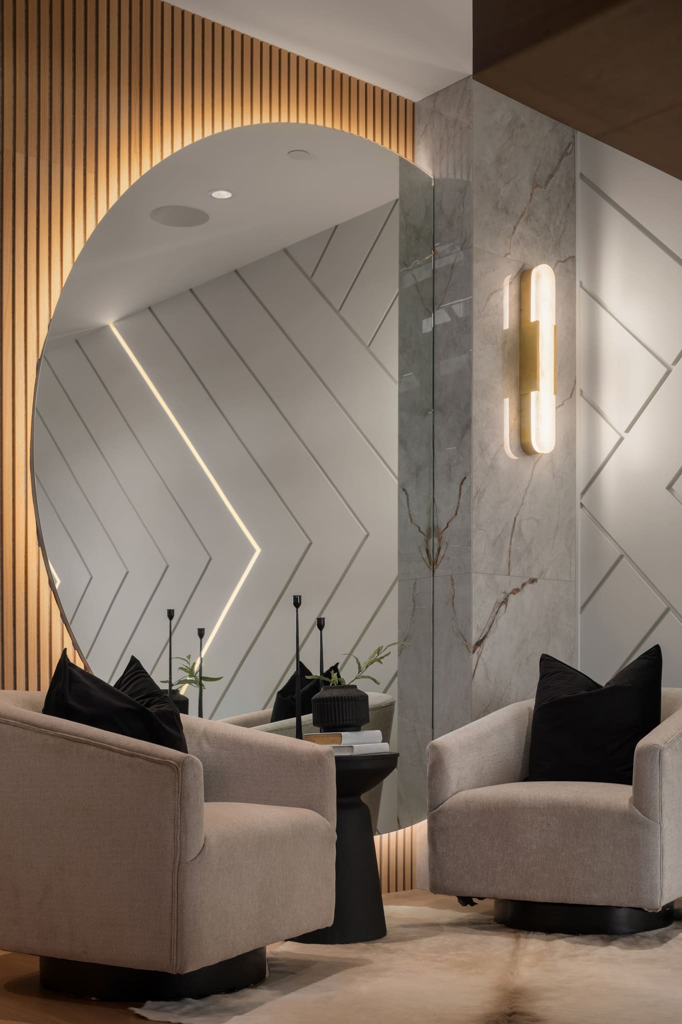 Modern living room featuring elegant design elements such as a circular mirror, textured wall with chevron patterns, and stylish seating. Located in the Pacific Northwest, this space exudes sophistication and comfort.