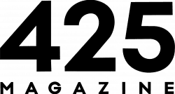 A black silhouette of a wizard holding a staff in one hand and casting a spell with the other. The wizard is wearing a tall, pointed hat and flowing robes, with stars and sparkles emanating from the spellcasting hand. The background is transparent.
