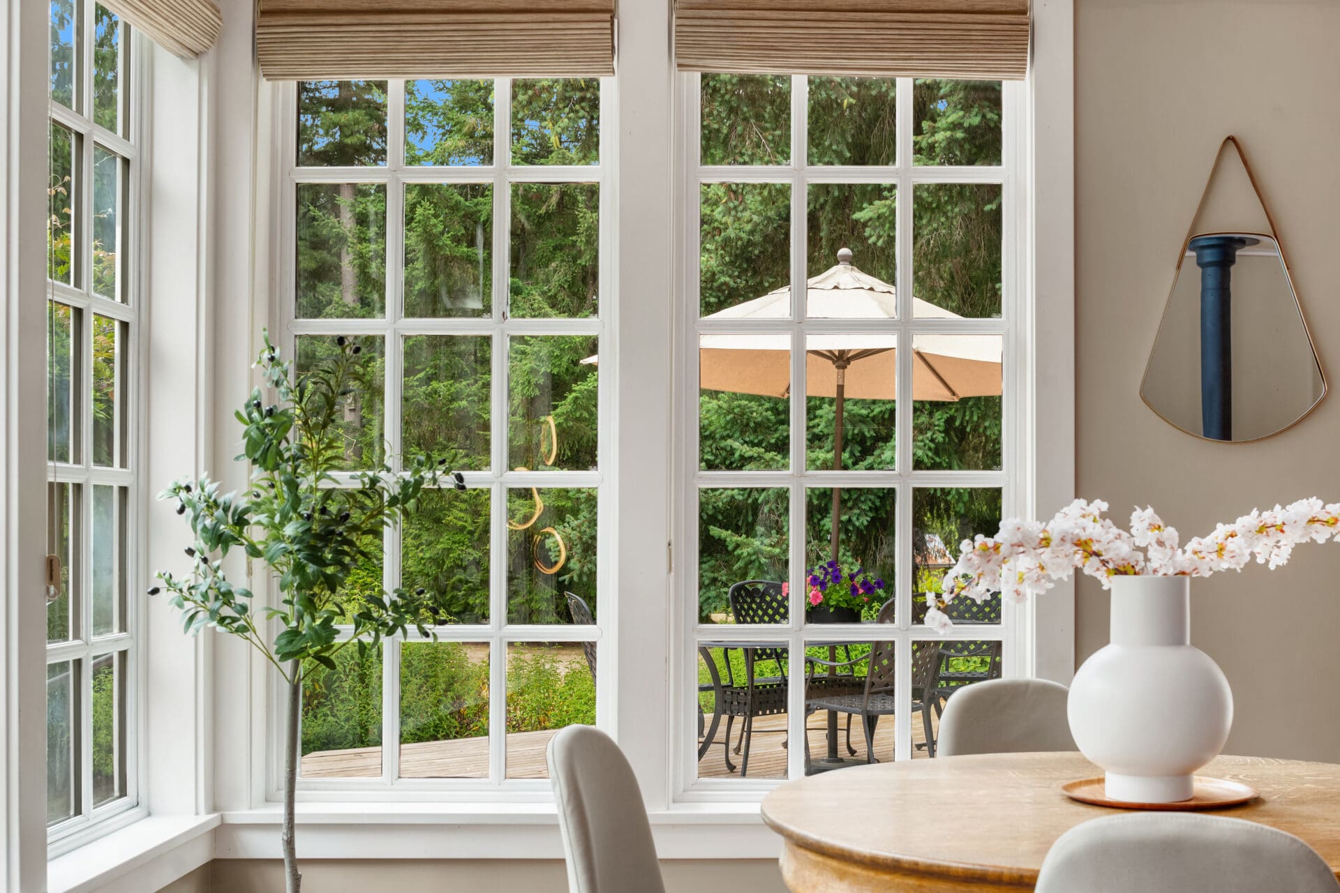 Bright and inviting dining area with large windows showcasing a serene outdoor patio, featuring modern decor and lush greenery, located in the Pacific Northwest.