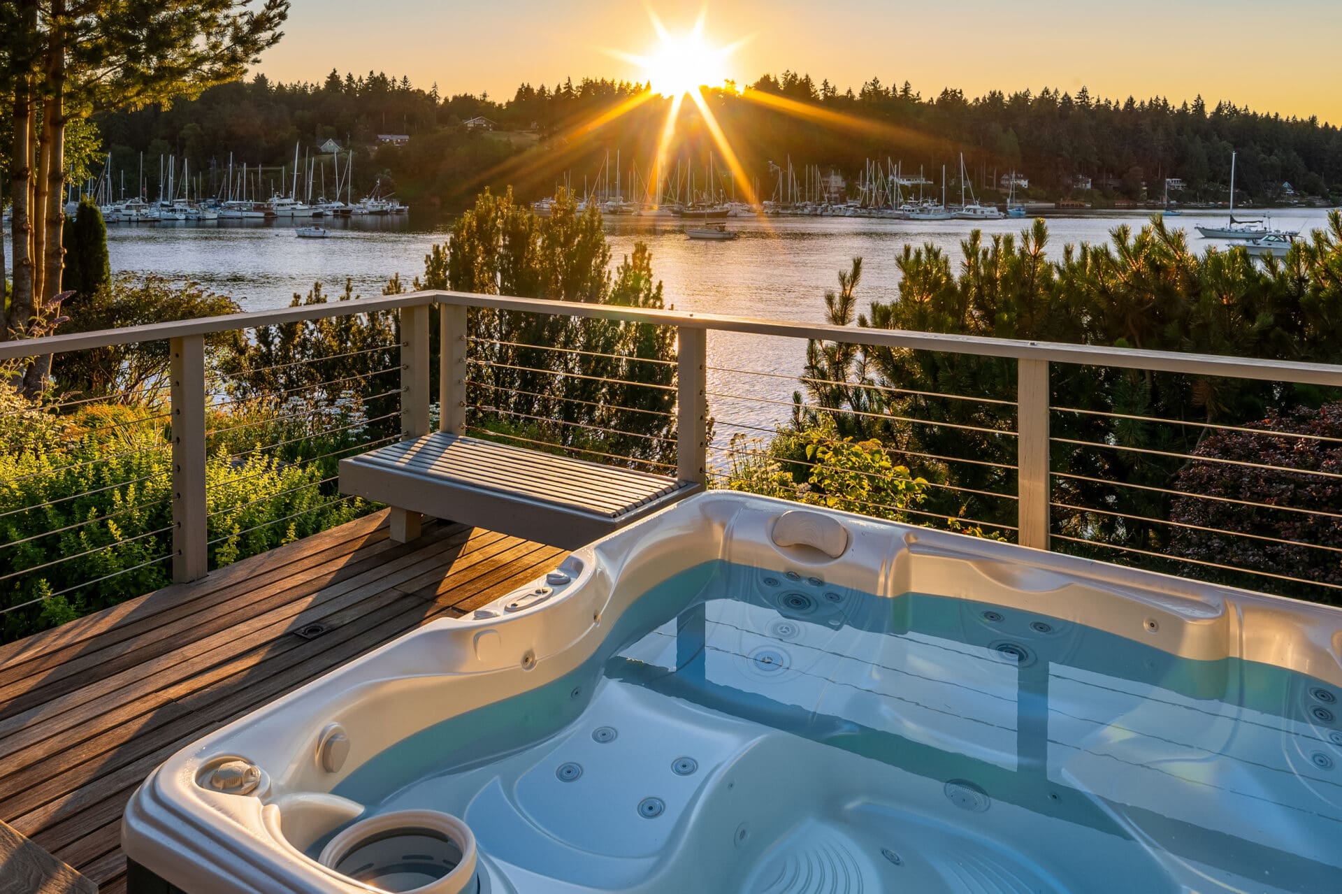 Luxury waterfront hot tub with stunning sunset views over the marina, featuring modern deck design in the Pacific Northwest.
