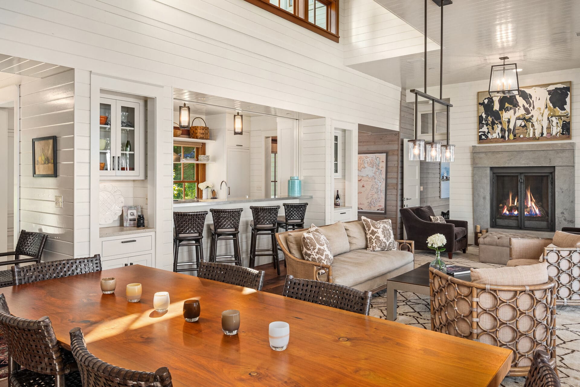 Spacious modern living room and dining area with a cozy fireplace, featuring elegant wood accents and natural light, located in the Pacific Northwest.