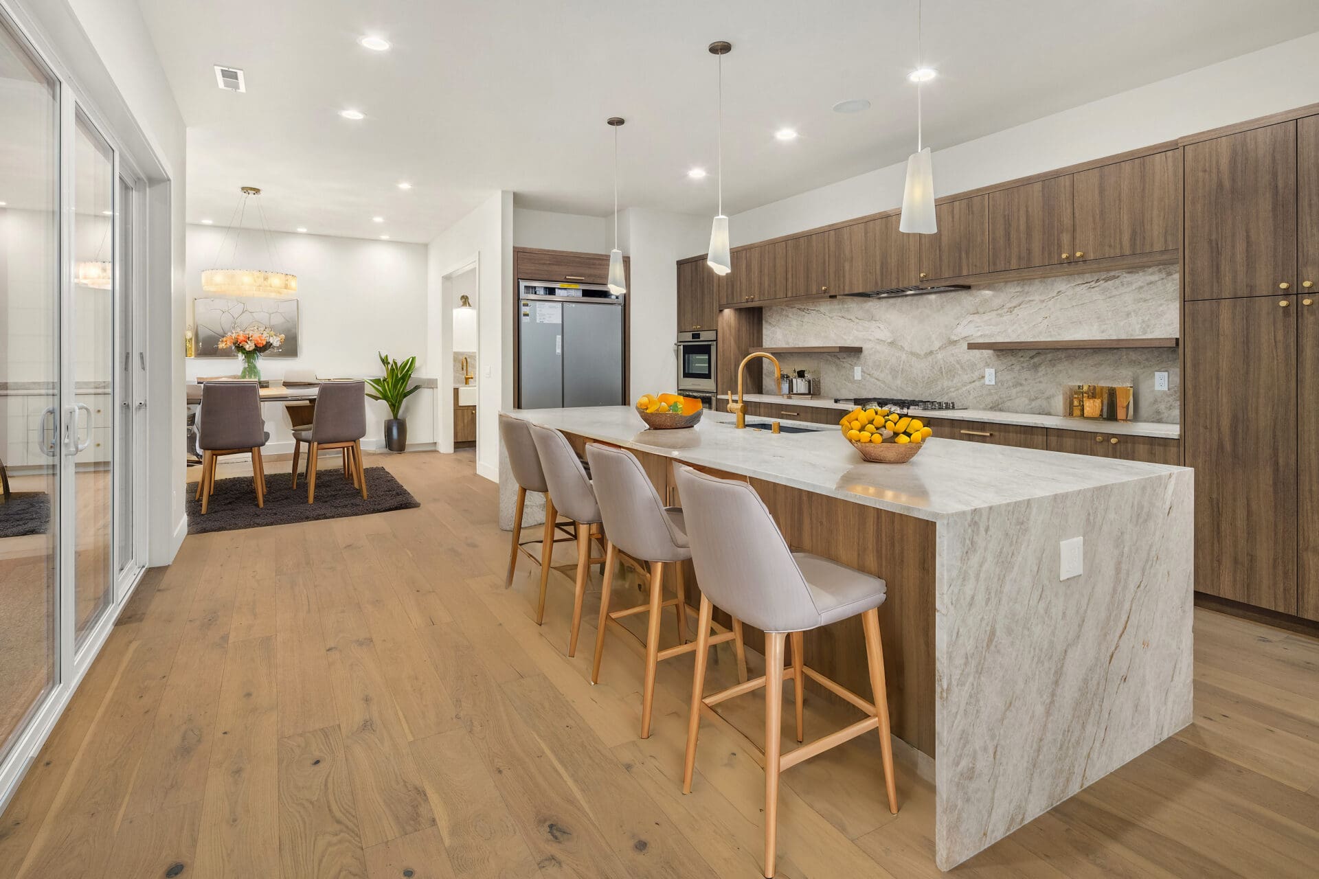 Modern kitchen with elegant marble countertops, wooden cabinetry, and stylish bar seating, located in the Pacific Northwest.