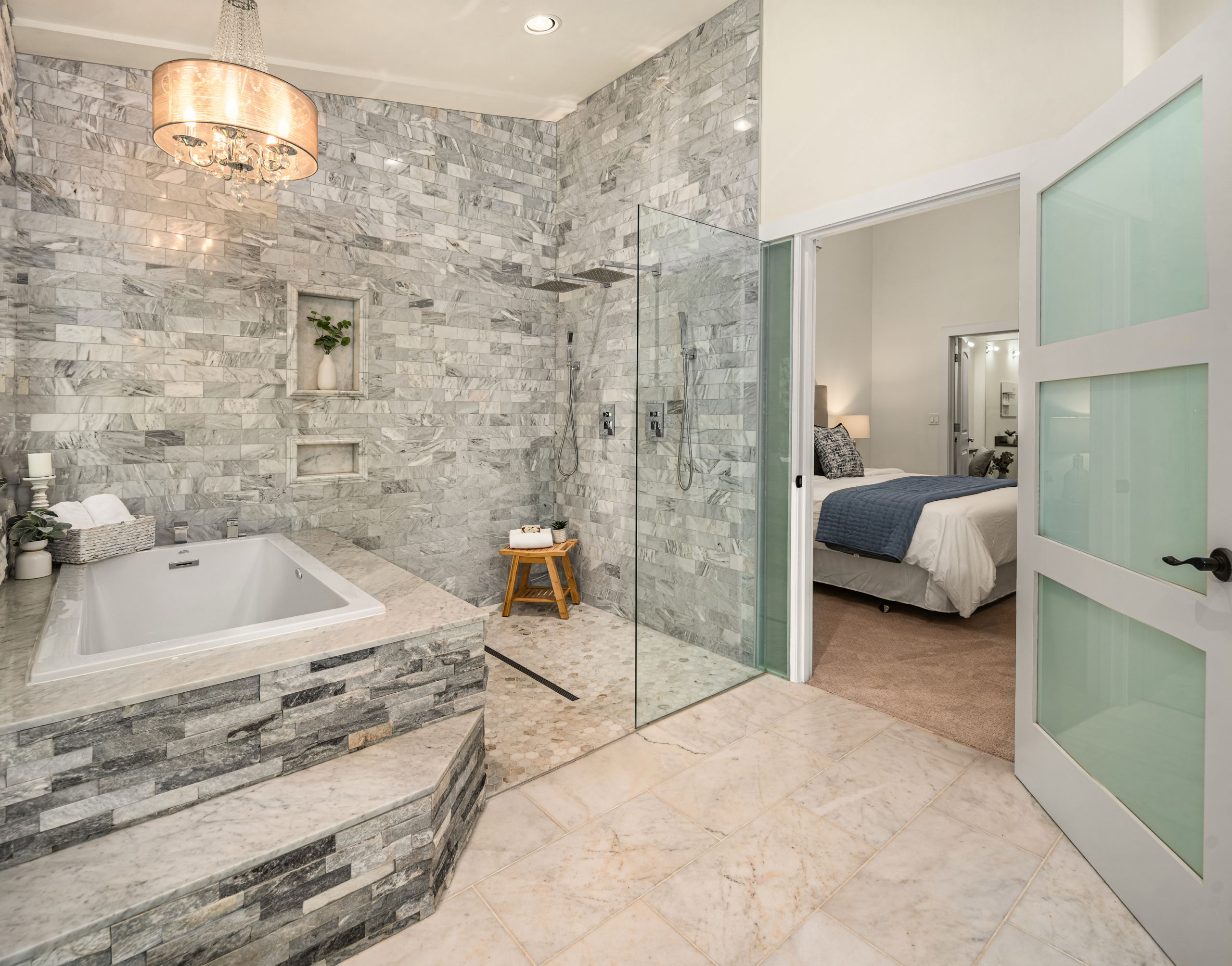Modern spa-like bathroom featuring a luxurious soaking tub, elegant marble stone walls, and a glass shower, located in the Pacific Northwest.