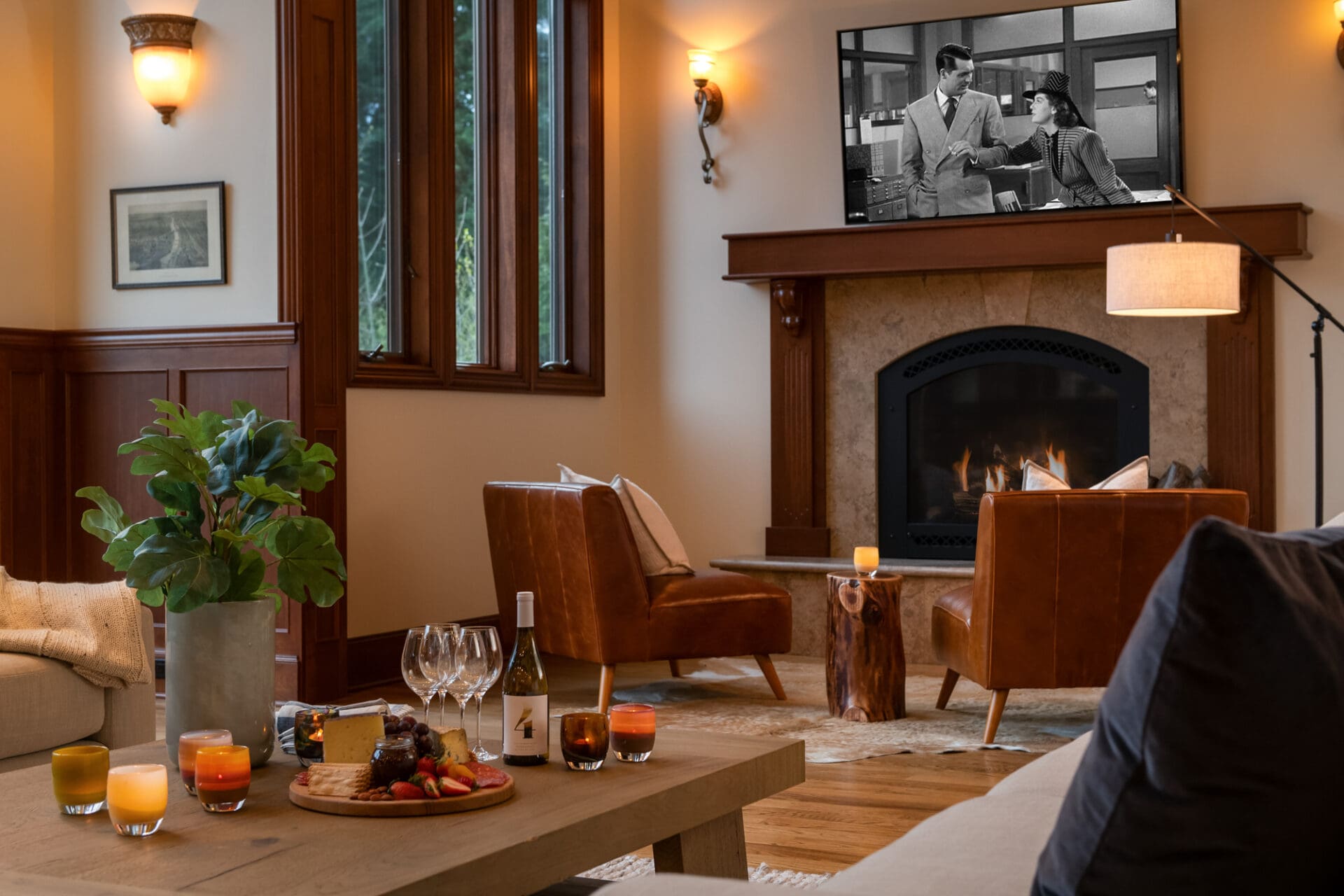 Cozy living room with modern design features, featuring leather armchairs, a stone fireplace, and a warm atmosphere. Ideal for entertaining with a wine and cheese spread, located in the Pacific Northwest.