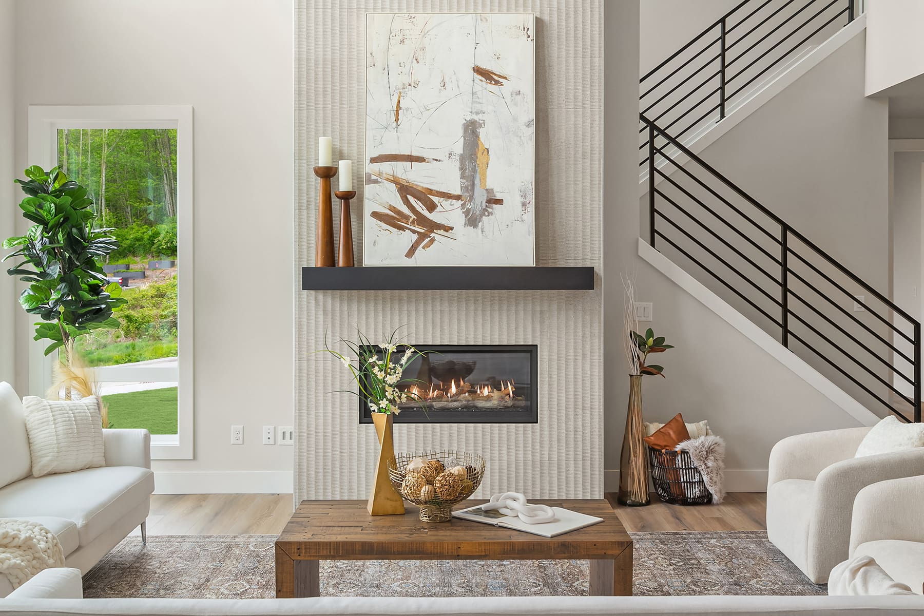 Modern living room with a cozy fireplace and elegant decor, featuring a stylish wooden coffee table and large windows overlooking greenery, located in the Pacific Northwest.