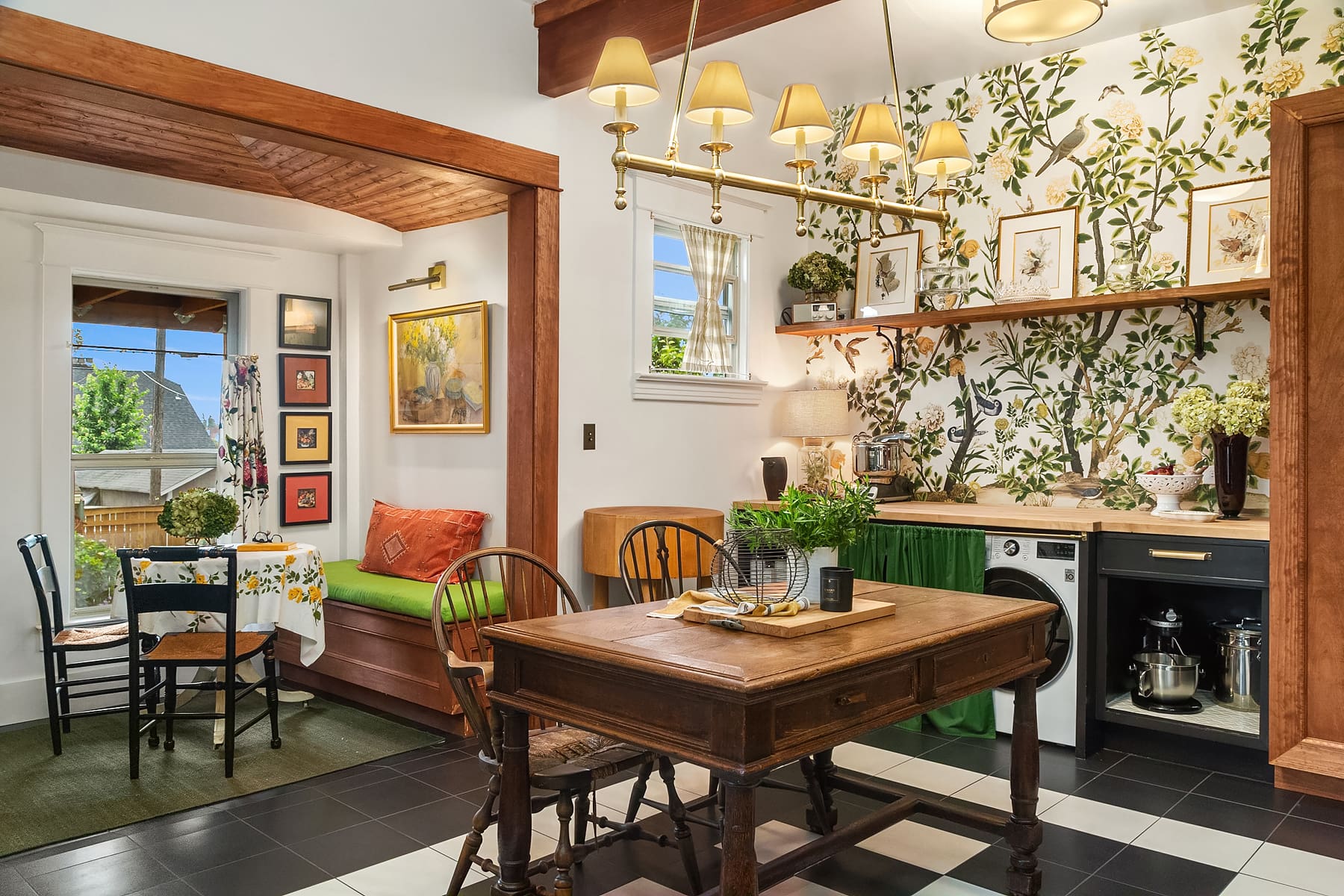 Charming kitchen space featuring a mix of modern and vintage design elements, highlighted by floral wallpaper, wooden accents, and a cozy dining area, located in the Pacific Northwest.