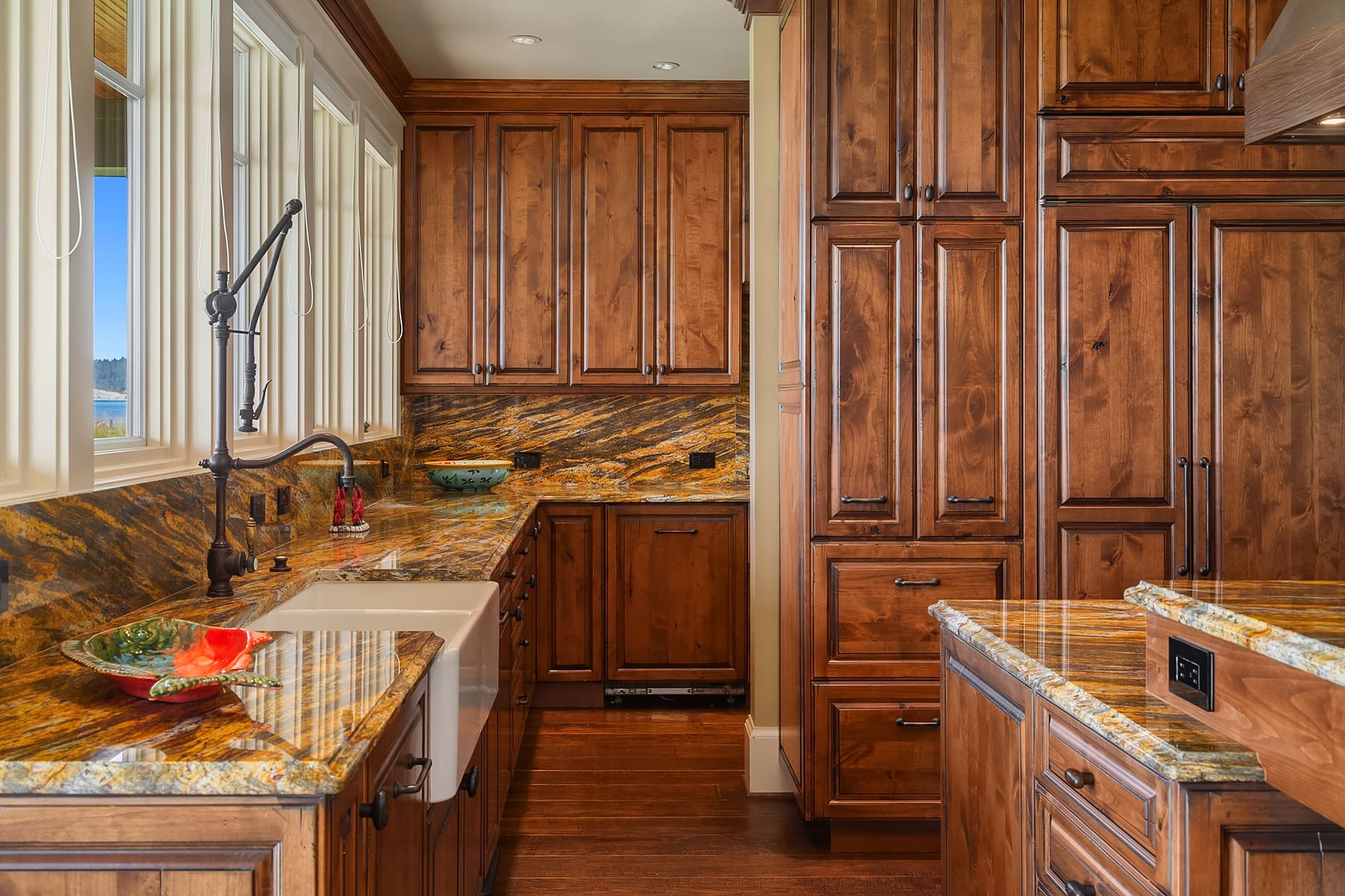 Luxurious kitchen featuring rich wooden cabinetry and stunning granite countertops, showcasing a modern design with an inviting atmosphere in the Pacific Northwest.