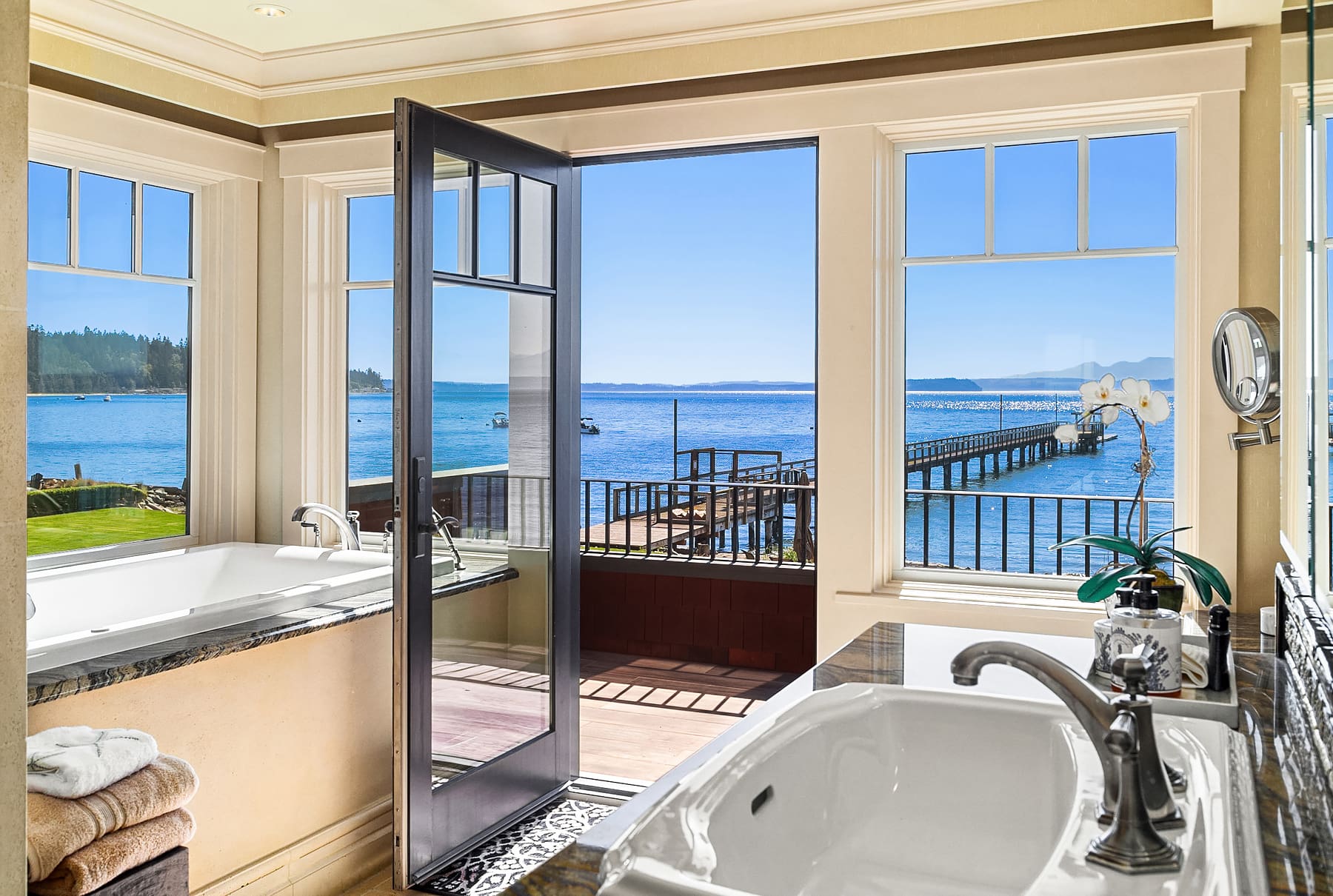 Luxurious bathroom with stunning waterfront views, featuring a soaking tub and modern fixtures, located in the Pacific Northwest.