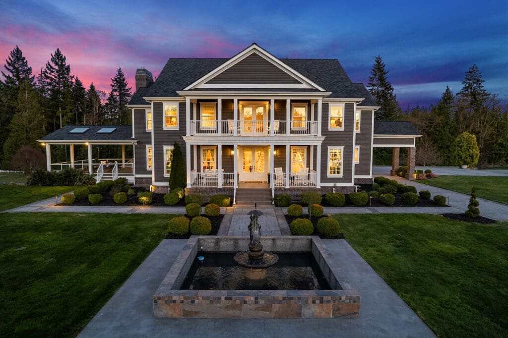 Elegant exterior view of a modern two-story home featuring a welcoming porch and landscaped garden, set against a twilight sky in the Pacific Northwest.